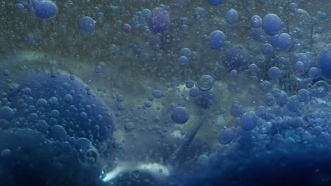 blue liquid background. macro shot of various air bubbles. slow mo.