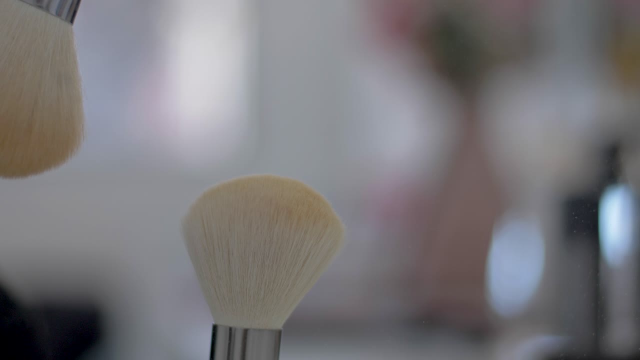 여성의 손에 있는 슬로우 모션 가루 먼지와 브러시