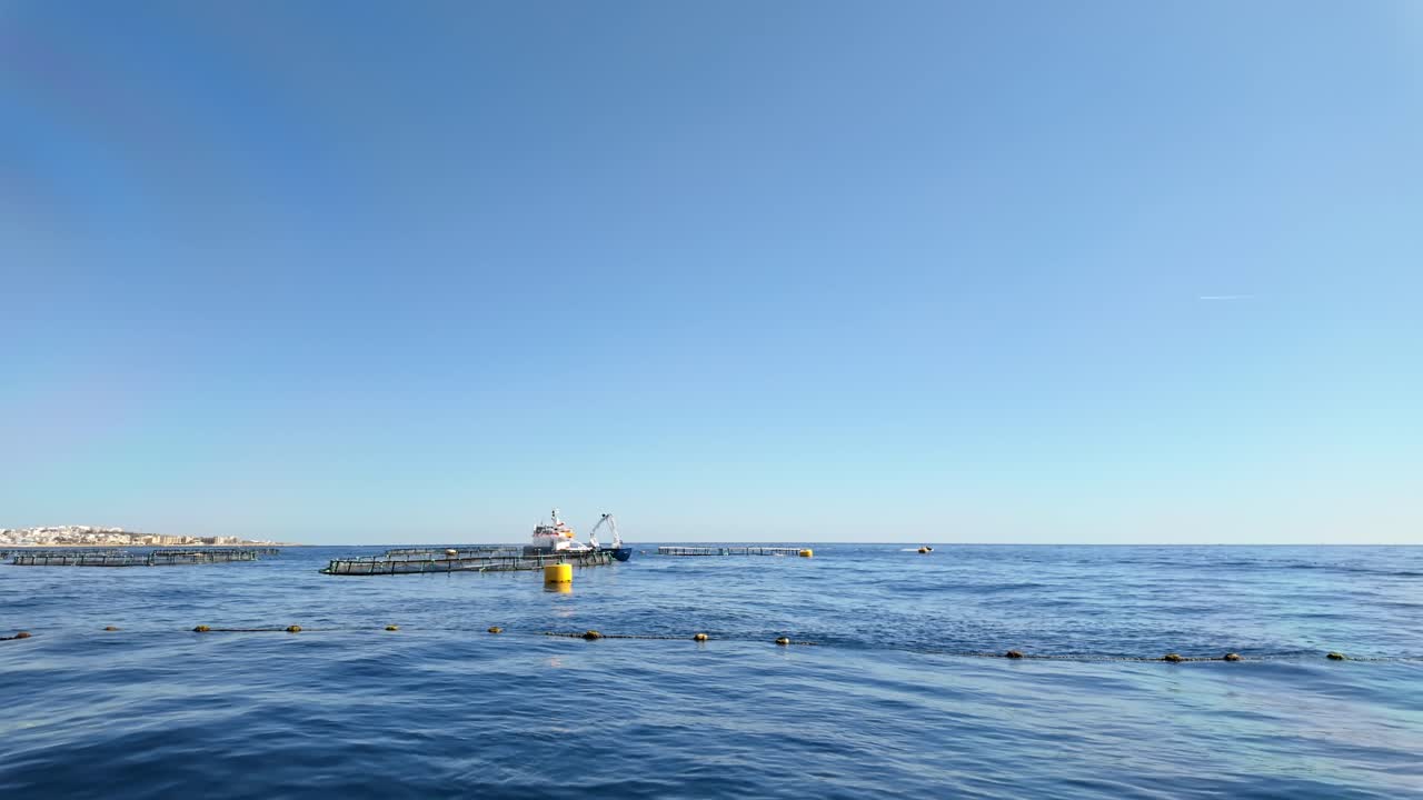 Service vessel spread water on the tuna nets over the water surface for feeding or oxygenation purposes in the Mediterranean Sea near Marsaskala, Malta.
