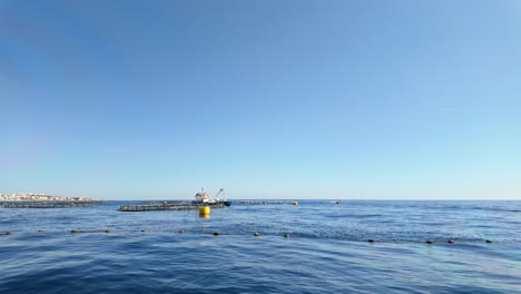 Service vessel spread water on the tuna nets over the water surface for feeding or oxygenation purposes in the Mediterranean Sea near Marsaskala, Malta.