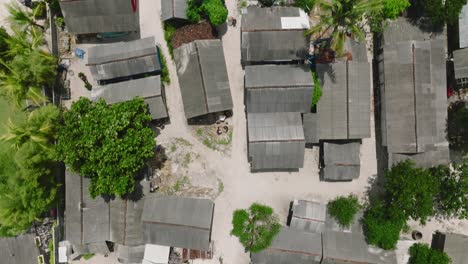 Seaweed-farmers-houses-at-beach-of-Nusa-Lembongan,-drying-seaweed-in-sun,-top-down