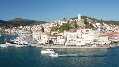 sailing yachts and boats along the waterfront in poros island, peloponnese, greece - aerial drone shot