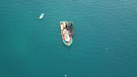 Vuela-Por-Encima-De-Un-Barco-Pesquero-Que-Tira-Tu-Red-Llena-De-Sardinas-En-El-Mar-Mediterráneo-Abierto,-Argelia