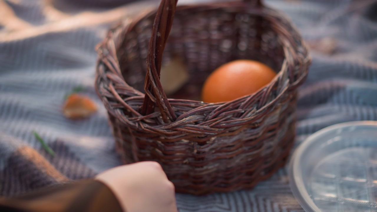 Wicker Basket With Egg on Picnic Blanket