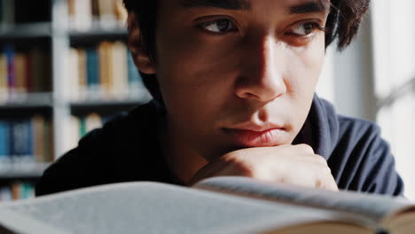 man reading a book in a library
