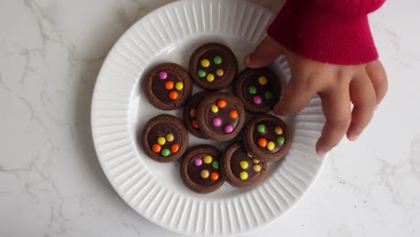 child eating colorful chocolate cookies