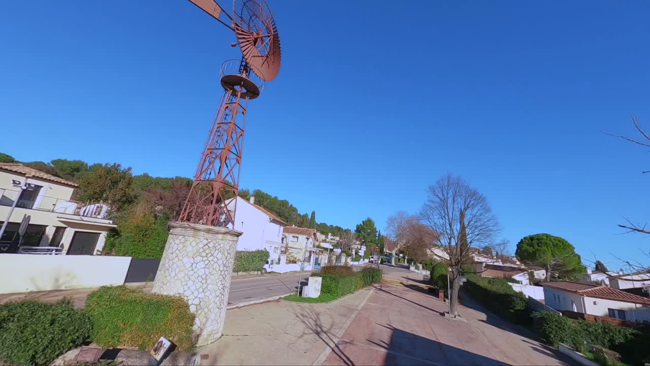emocionante vuelo de drones fpv alrededor de un viejo molino de viento gigante en el corazón de un pueblo
