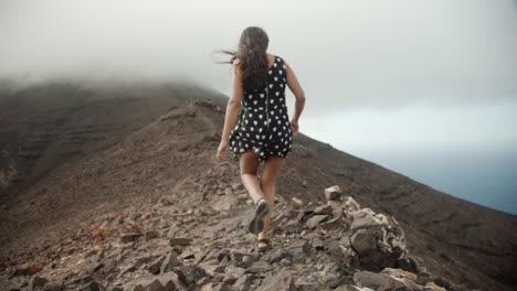 young woman walking on a crest of mountain in fuerteventura canary island spain