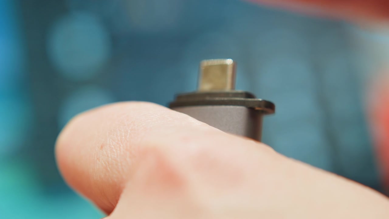 Blue light supports connection. Close up of hands securing connection with glowing indicator. Technician ensures stable connection by tightening adapter while background displays blue glow