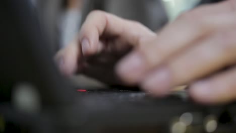 close-up of a man's hands typing intensely on a blurry keyboard in a dimly lit office