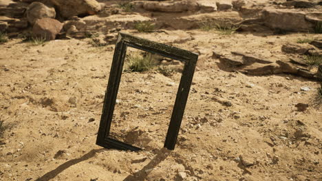 desert landscape featuring an empty frame standing on sandy terrain