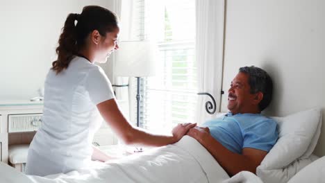 Female-doctor-giving-glass-of-water-to-senior-man-4k