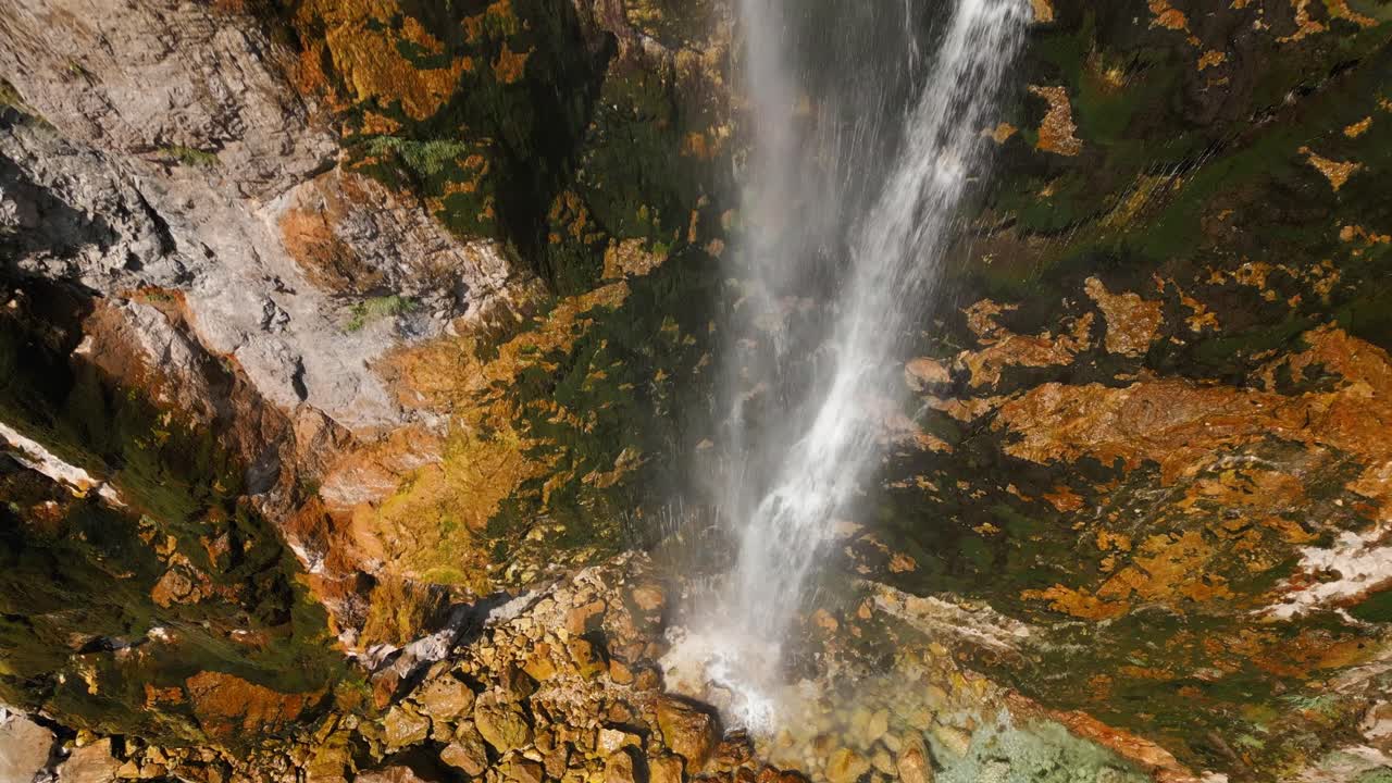 Clear mountain waterfall flowing over mossy rocks into a turquoise pool in Albania. Peaceful and natural landscape perfect for travel or nature footage