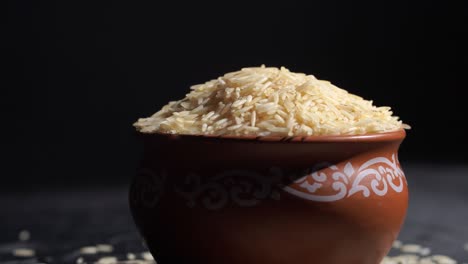 raw rice grain in wooden bowl