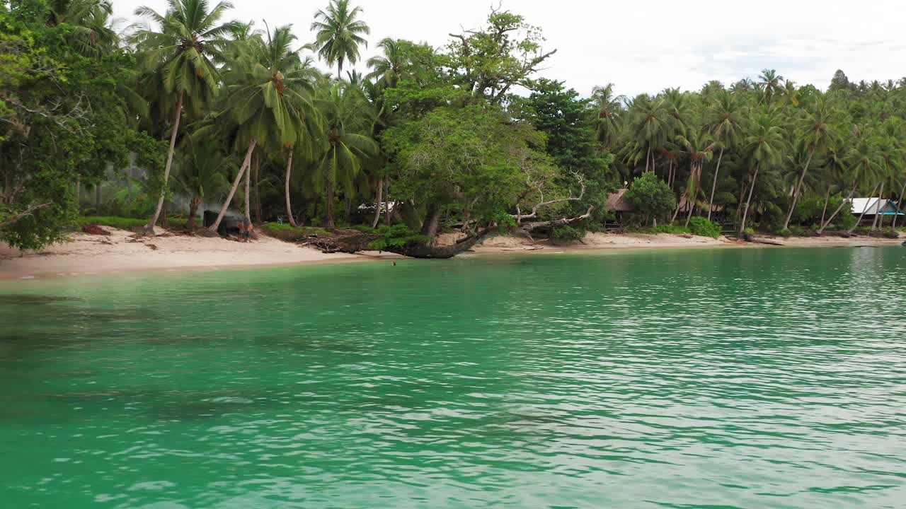 Aerial parallax shot of remote beach fishing village on Indonesian island
