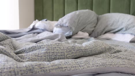 messy bed with pillows and blankets