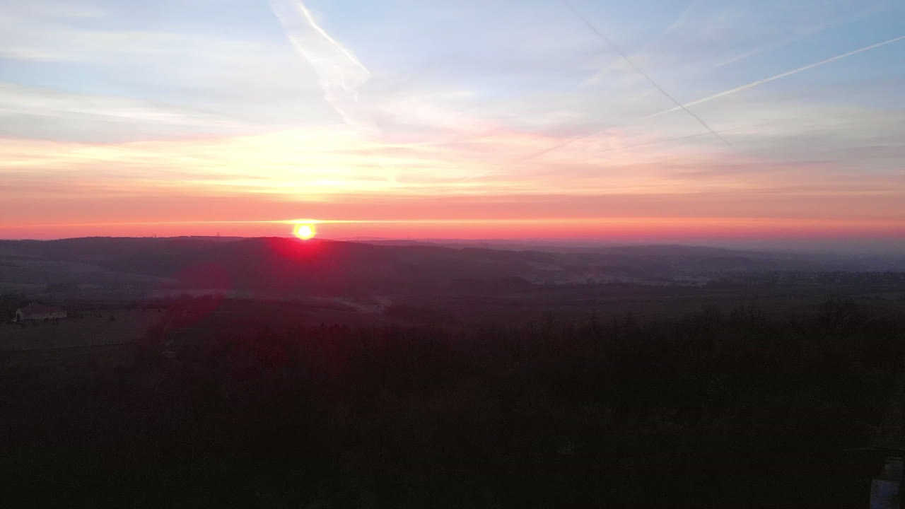 vista aérea de retroceso de un punto de vista cristiano en la cima de una colina al atardecer