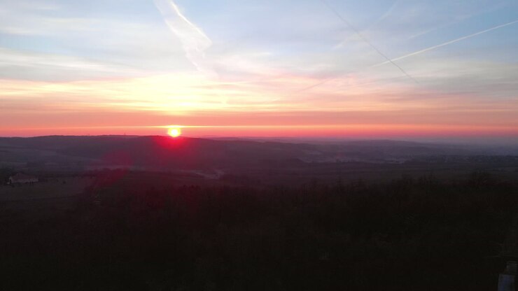 Veduta aerea in allontanamento di un punto panoramico cristiano in cima a una collina al tramonto