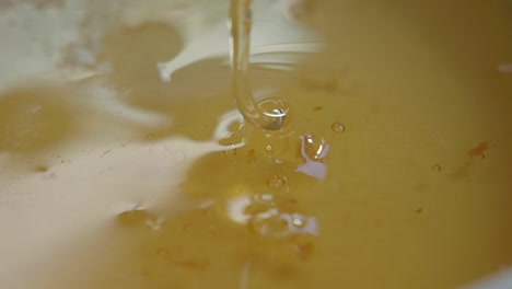 close-up of golden honey pouring