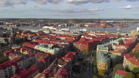 aerial of gothenburg city with many buildings, river and port, arc shot