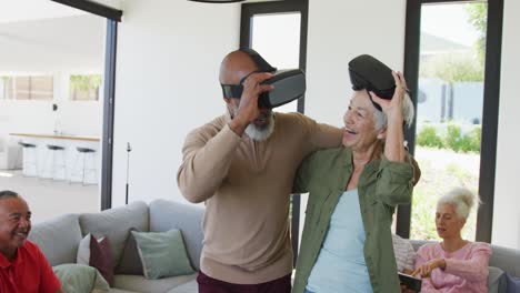 happy senior diverse people using vr headsets at retirement home