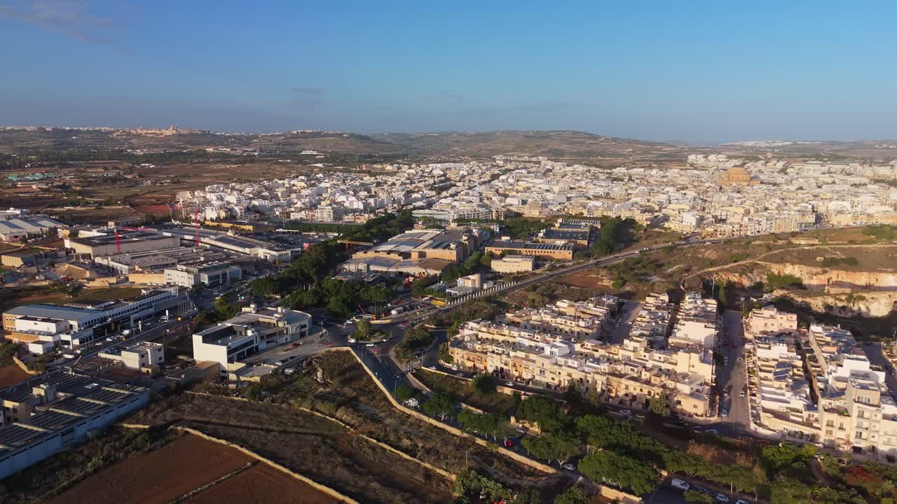 Morning aerial view of the Lija industrial facilities and shopping malls with the Mosta cityscape in the background in Malta