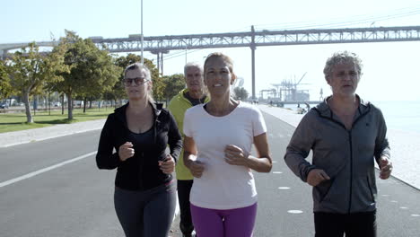 active older joggers running on promenade