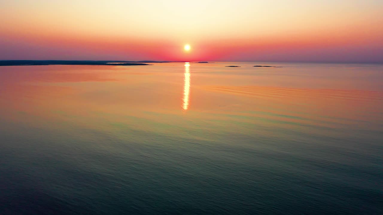 해가 지는 색이 해안을 따라 바다의 파도에서 반사됩니다.