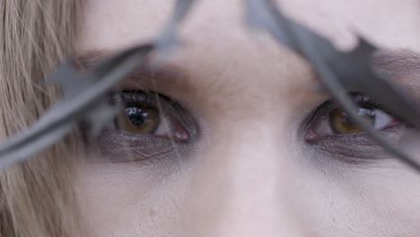 close-up of a woman with barbed wire on her forehead