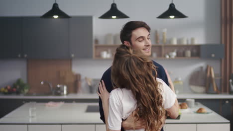 pareja romántica abrazada en la cocina de la casa. hombre y mujer amorosos mirándose el uno al otro