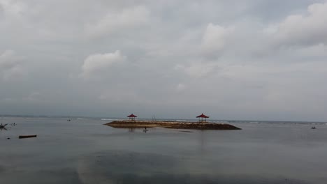 gazebo pagoda float on sanur beach bali indonesia cloudy weather blue sea white skyline a man paddles his canoe, indonesia, calm waves