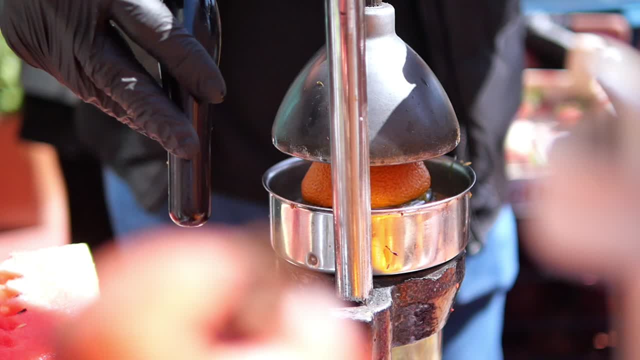 Squeezing Oranges at a Street Food Vendor