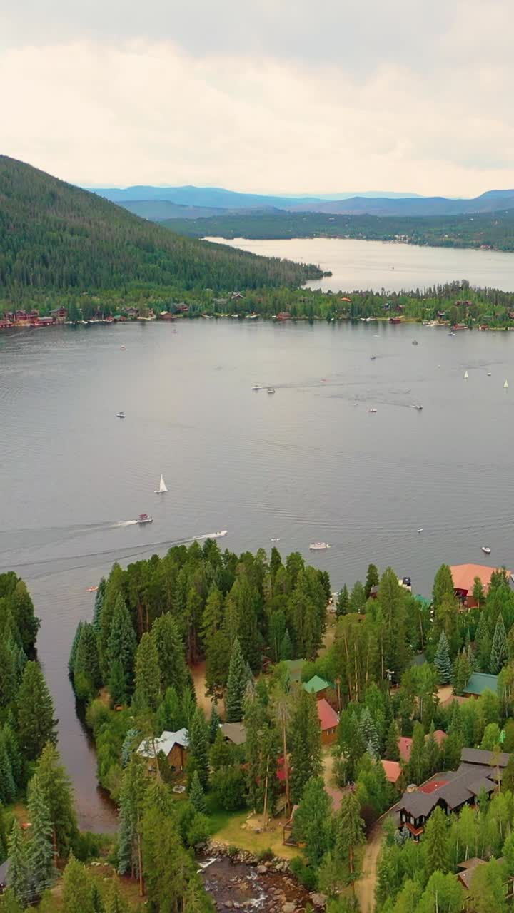 Vertikale erhöhte Luftaufnahme des Big Bear Lake Kalifornien mit Bootsliegeplätzen, Ufergebäuden, ruhigem Wasser und malerischen, mit Kiefern bewachsenen Hängen bei hellem Sommerlicht