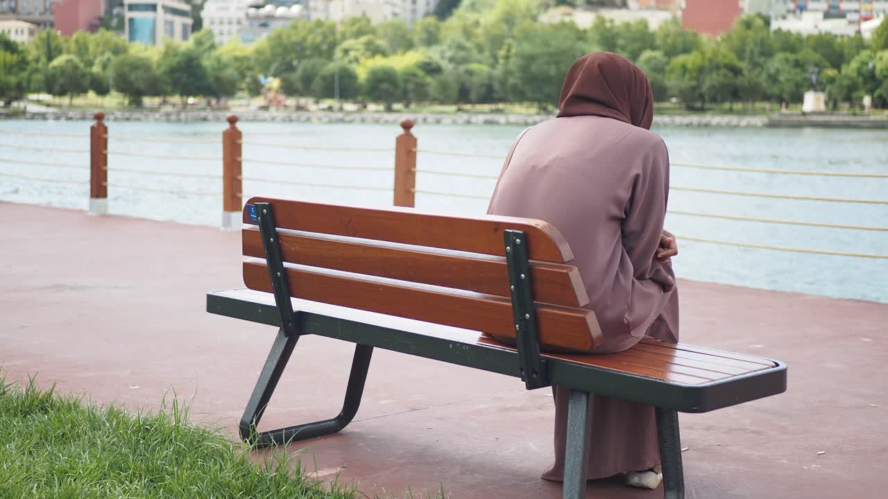 호수 의 벤치에 앉아 있는 여자