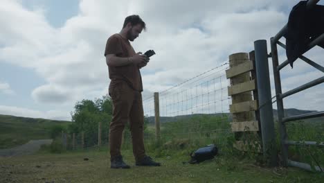 male drone pilot using and studying closely remote control to fly drone