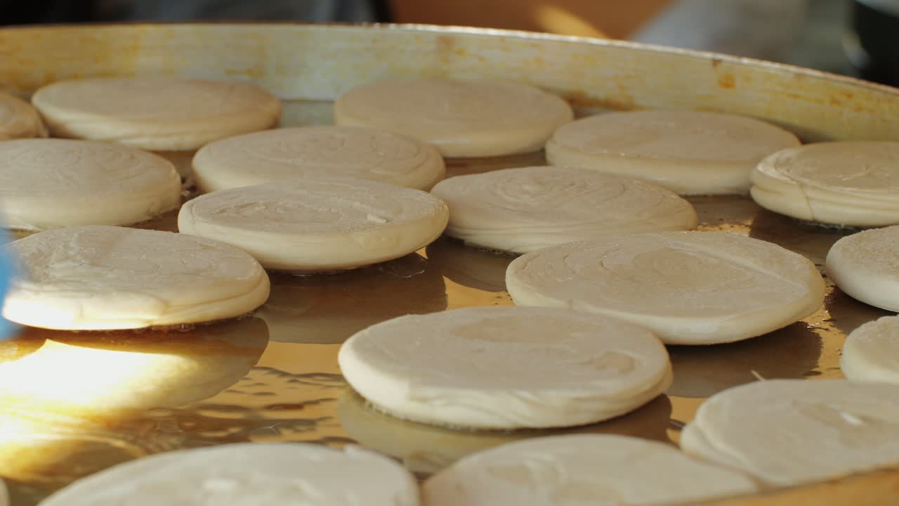 Cooking raditional chinese steamed buns Mantou in oil close-up. Mantou or bao bun with rice, green,spicies and meat. Local streetfood market outdoor. High quality 4k footage