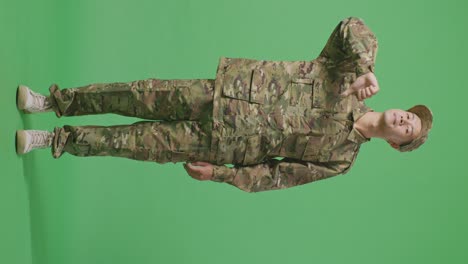 Full Body Of Asian Man Soldier Showing Thumbs Down Gesture To Camera While Standing In The Green Screen Background Studio