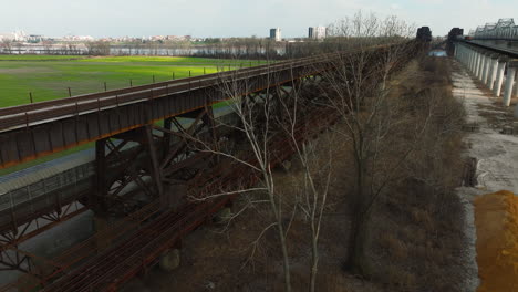 rusty railroad bridge overgrown with trees in west memphis delta regional river park