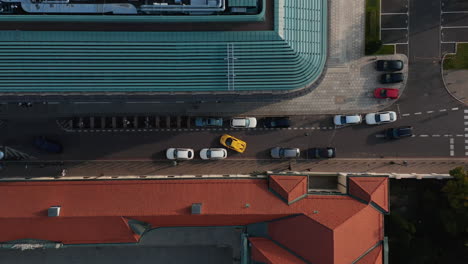 Vista-Aérea-De-Arriba-Hacia-Abajo-De-Las-Maniobras-De-Automóviles-En-El-Casco-Antiguo.-Coche-Deportivo-Amarillo-Rápido-Que-Sale-Del-Lugar-De-Estacionamiento-En-Una-Calle-Estrecha.-Varsovia,-Polonia