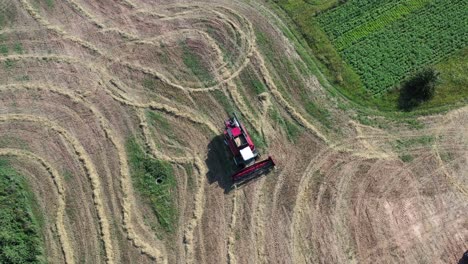 aerial view of a combine harvester working in a rural field