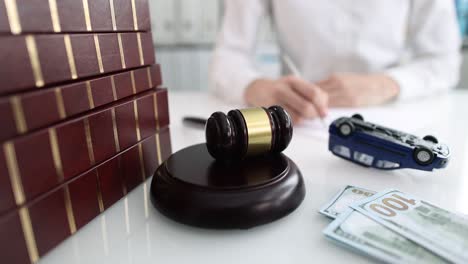 judge gavel with money and overturned toy car lying against background of woman with documents closeup 4k movie