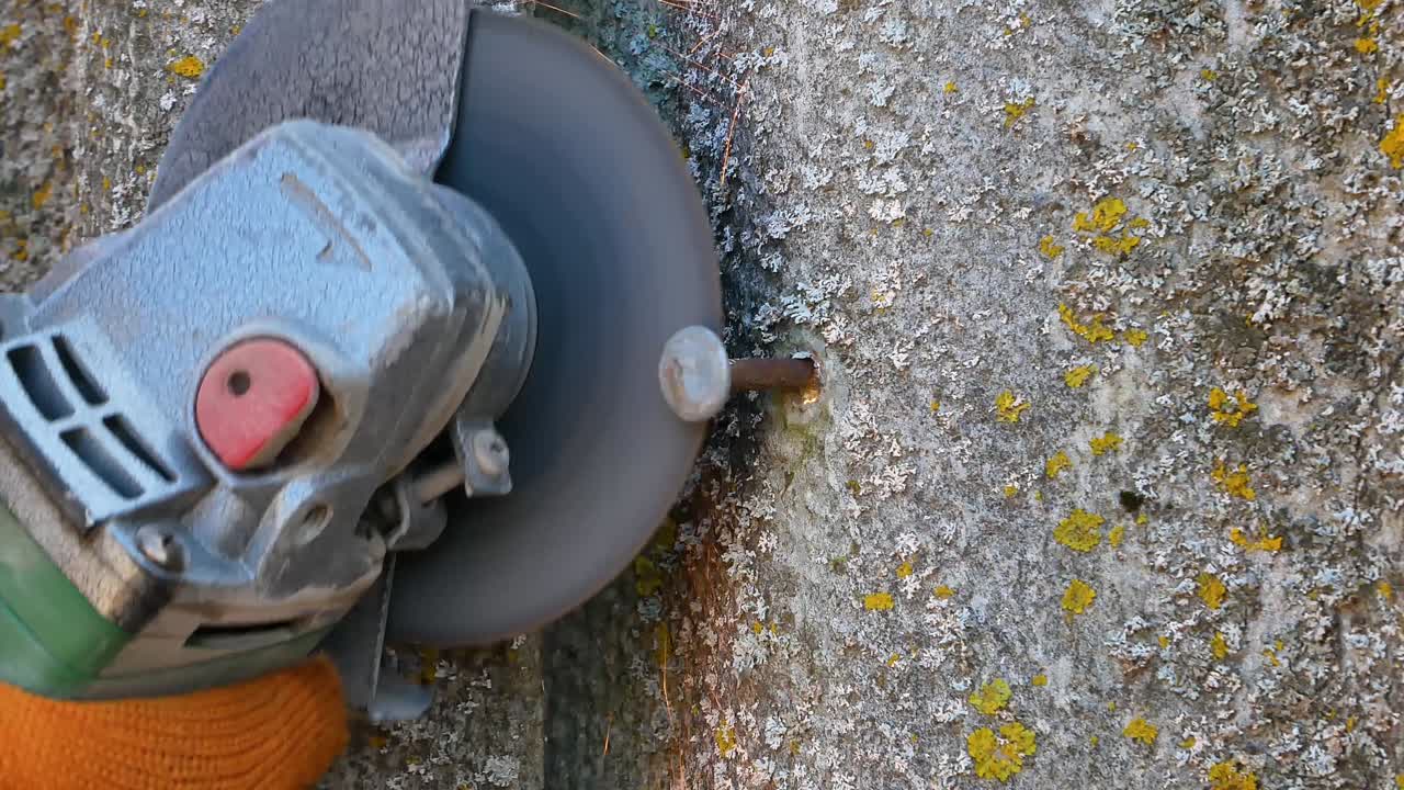 cortar un clavo de hierro con un disco de molienda eléctrica. herramientas de mano eléctricas. herramienta de máquina de molienta. cortar discos para metal. cortar metal. clavo de acero. chispas voladoras. equipo de trabajo. trabajo profesional