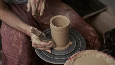 the potter makes a jug of clay. ceramist. a man makes a vase on a potter's wheel