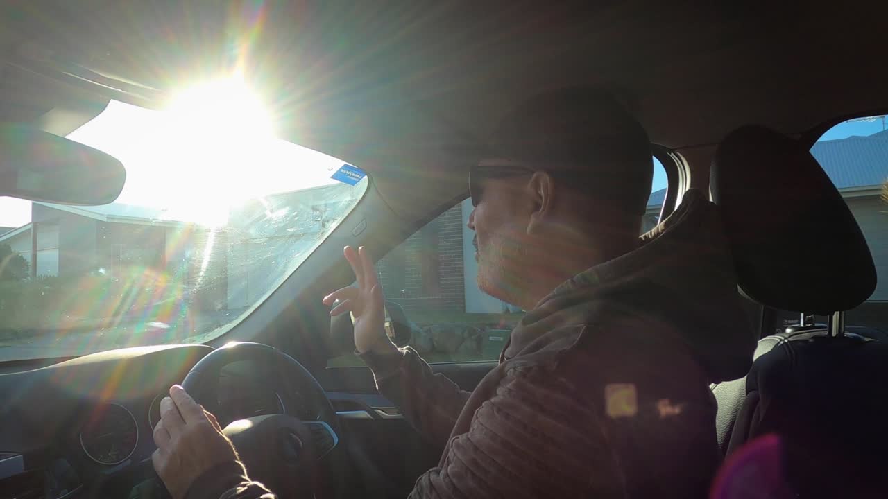 행복한 수은 은 날 차에서 춤을 추고 노래를 부르고 있습니다. 모자와 선글라스를 입고 있습니다.