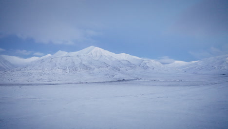 drone shot revealing a wind blown, snowcovered svalbard landscape