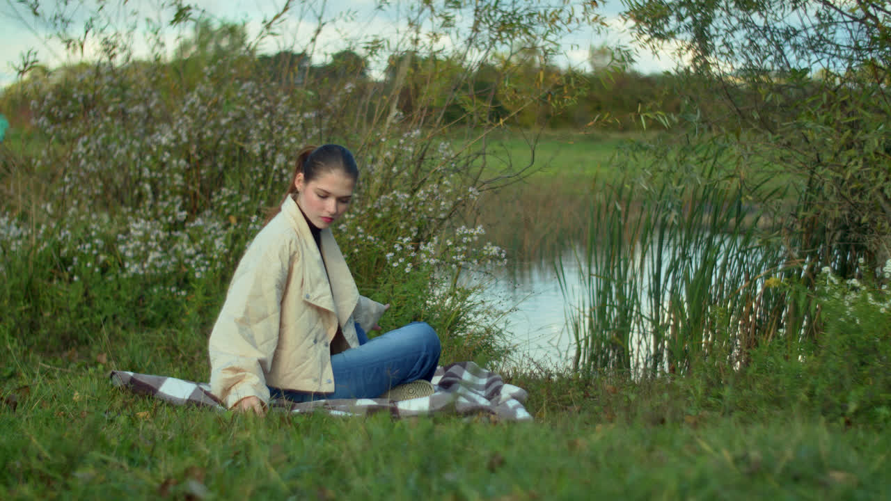 Woman relaxing by a lake in autumn