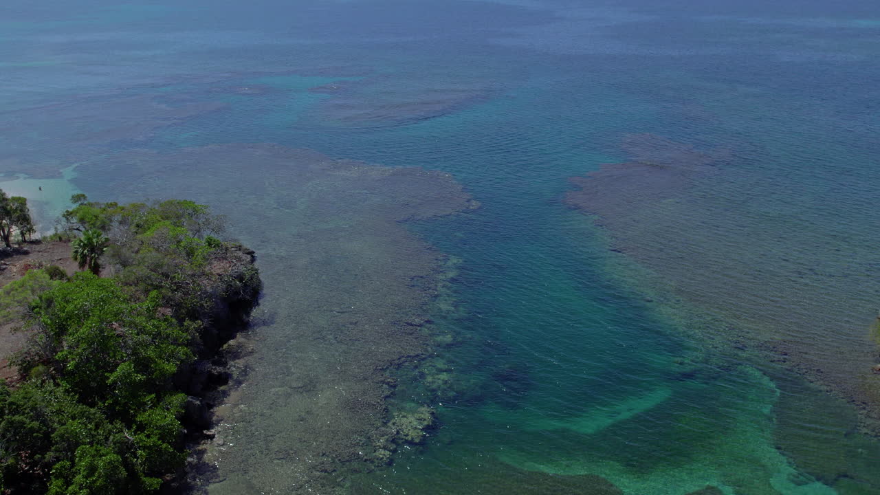 Aerial shot of a quiet ocean bay with tropical caves at the Puerto Plata