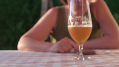 beer glass lifted for a sip in sunny home garden