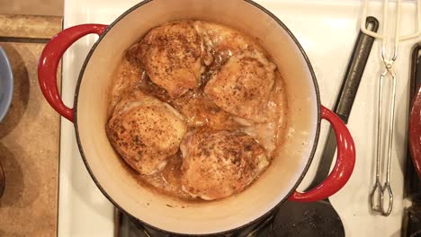 overhead view of free-range chicken thighs roasting in hot oil in the dutch oven - pot roasted chicken series