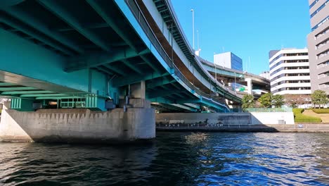 passing under a bridge view from a boat in tokyo